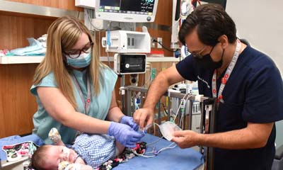 Dr. David Askenazi and Children's nurse Amanda O'Hara put a Zorro-Flow device on a patient.